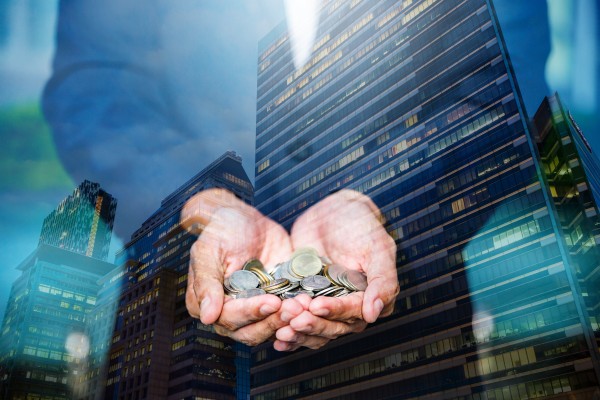 Double exposure image of a businessperson holding coins